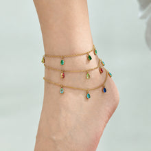 Gold-tone teardrop zircon anklets layered around the ankle