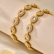 Pair of gold bracelets with repeating teardrop zircon floral links