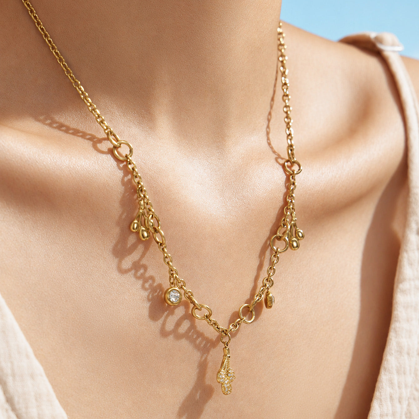 Close-up of a gold teardrop zircon necklace arranged around the neckline