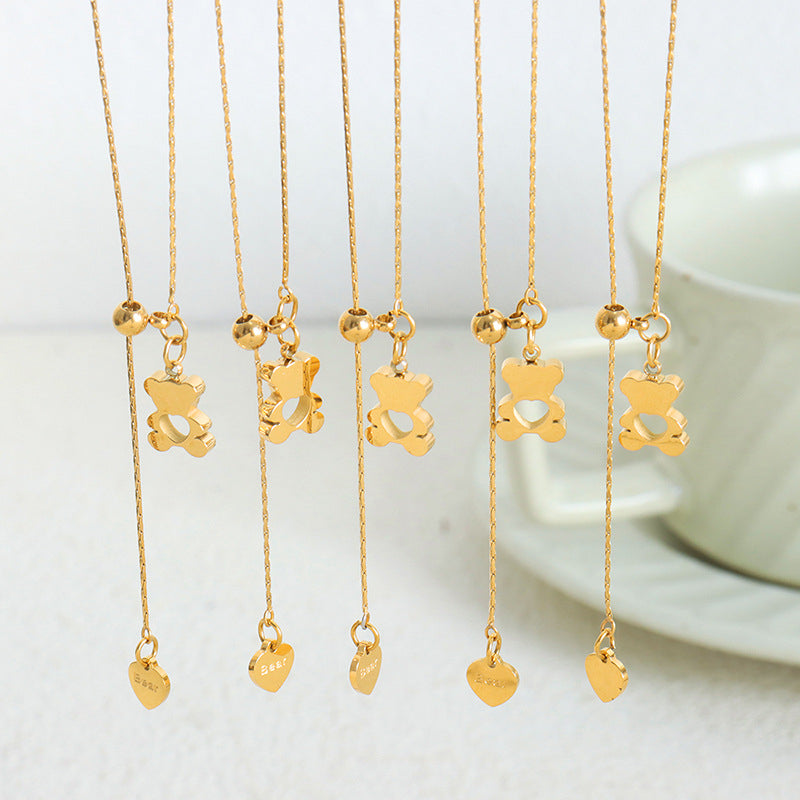 Gold teddy bear pendant necklaces displayed in a row with adjustable hanging chains and heart charms