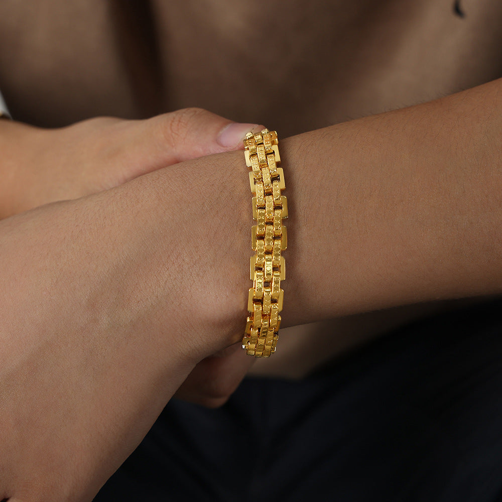 Gold 316L stainless steel lobster clasp bracelet on male wrist, minimalist design, waterproof, hypoallergenic, perfect for streetwear and fashion boutiques