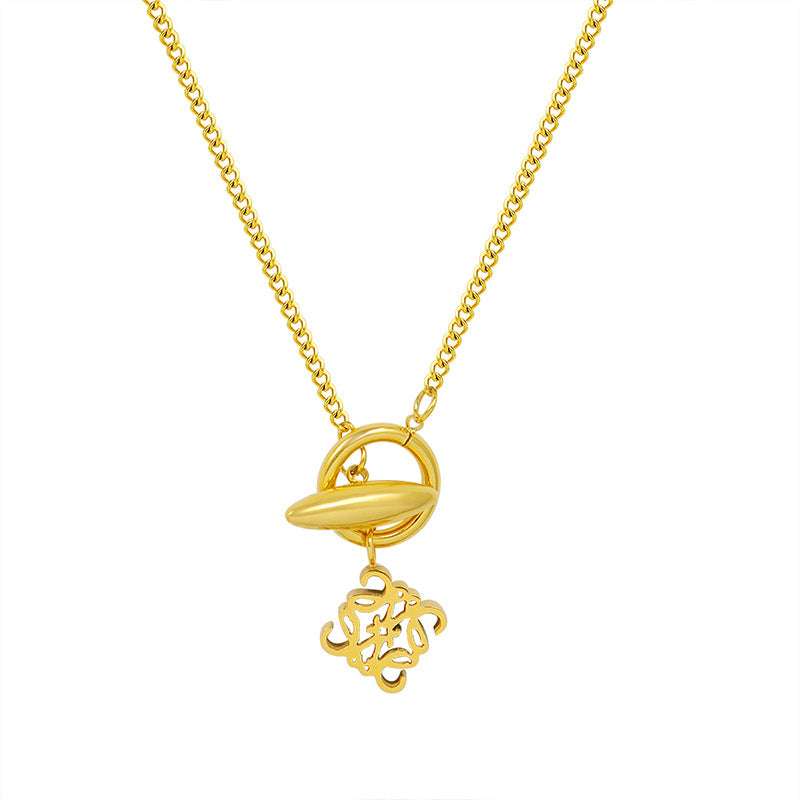 Gold-tone toggle pendant necklace with ornamental symbol charm and front clasp