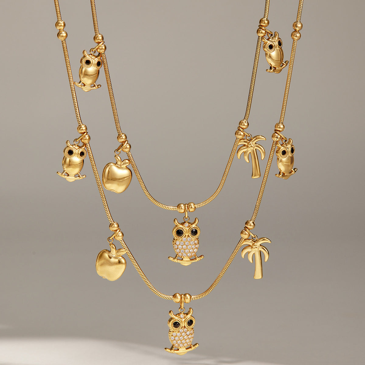 Gold-tone stainless steel necklaces displayed together with animal and tropical charms