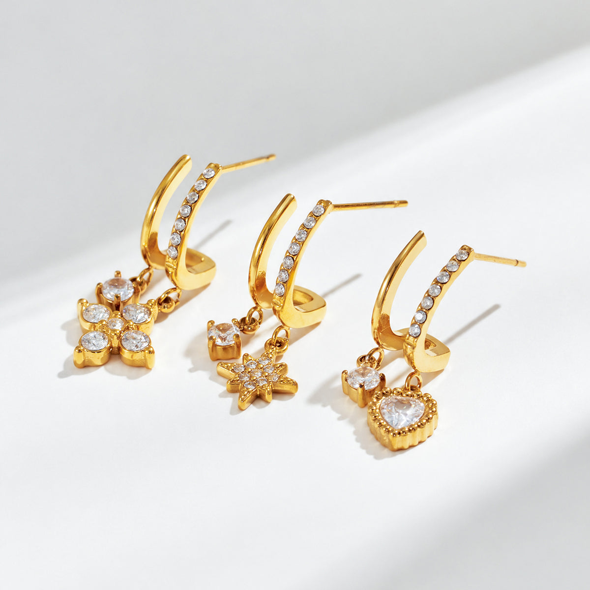 Assorted gold-tone stainless steel CZ charm drop earrings with multiple motifs