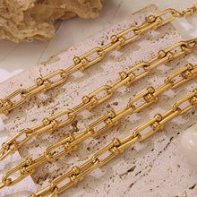 Close-up of gold U-link chain jewelry with elongated polished links