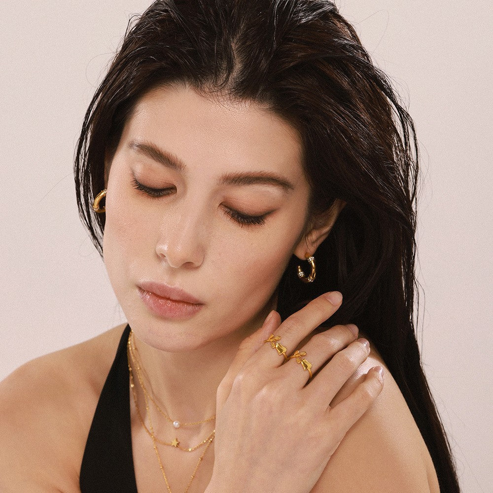 Model wearing a gold-tone vintage rose open ring in a soft fashion portrait