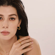 Close-up portrait of a model styling a gold-tone rose open ring on the hand