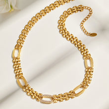 Gold-tone watch link necklace flat lay with decorative zircon-set oval links