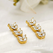 Gold wheat motif drop earrings displayed on a light jewelry background