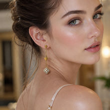 Gold white crystal clover dangle earrings shown in a model back-view portrait