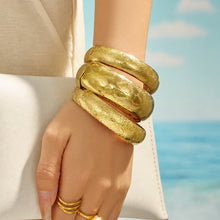 Gold wide engraved bangle styled on the wrist