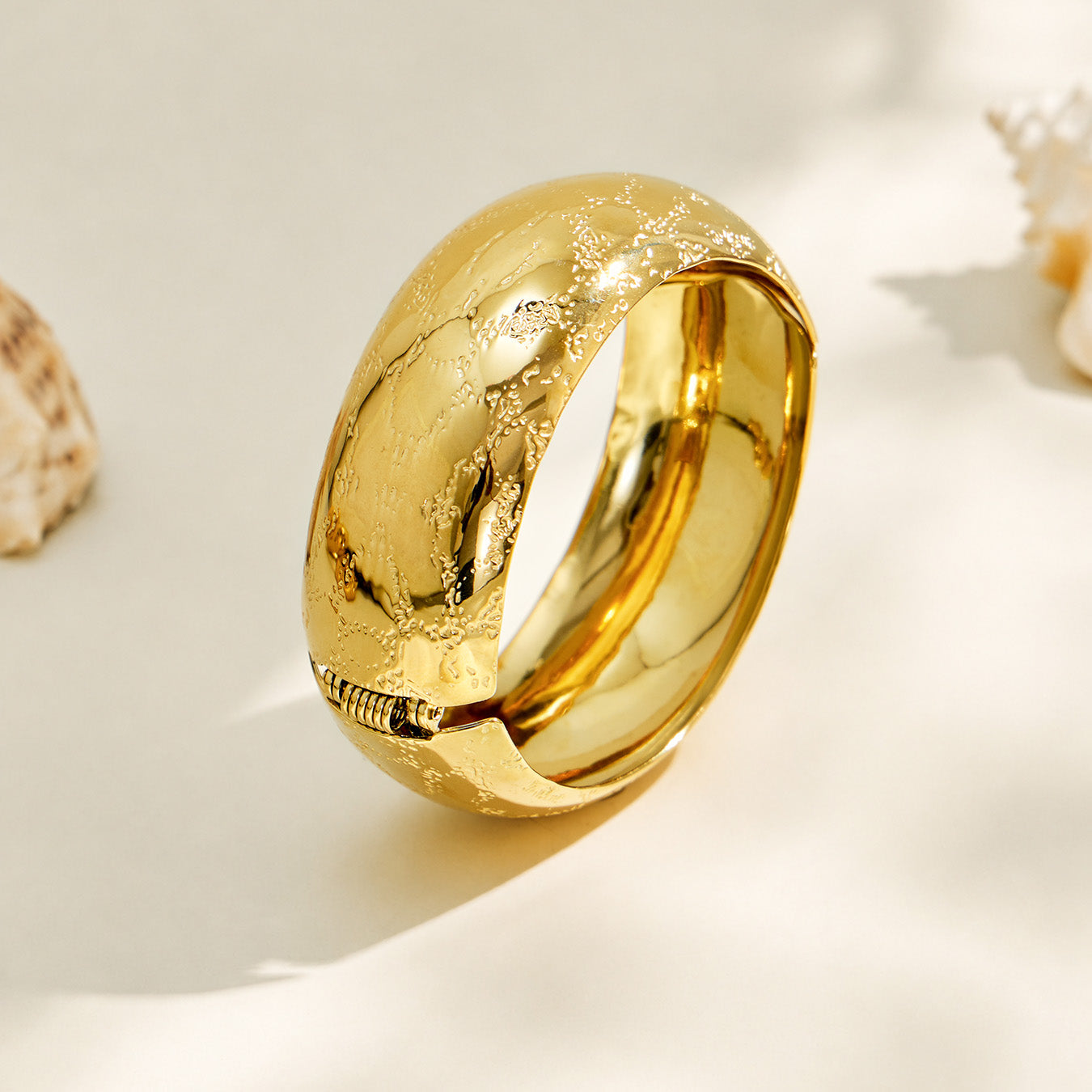 Multiple gold wide bangles with different floral engraved designs