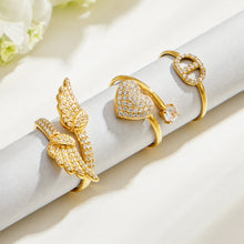 Gold wing and geometric cubic zirconia rings displayed together on a light background