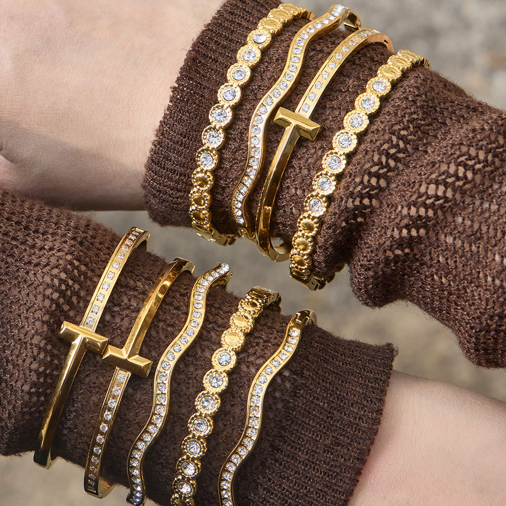 Gold zircon bangle bracelet stack on brown knit sleeve with H buckle cuff, wavy zircon bangle and round zircon bracelet