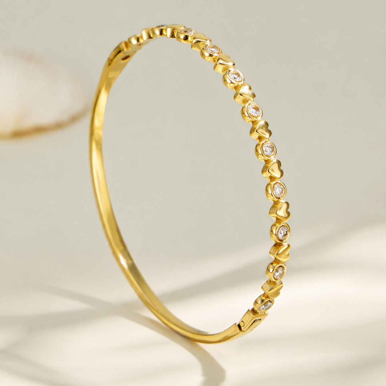 Side profile of a slim gold zircon bangle with a polished geometric edge