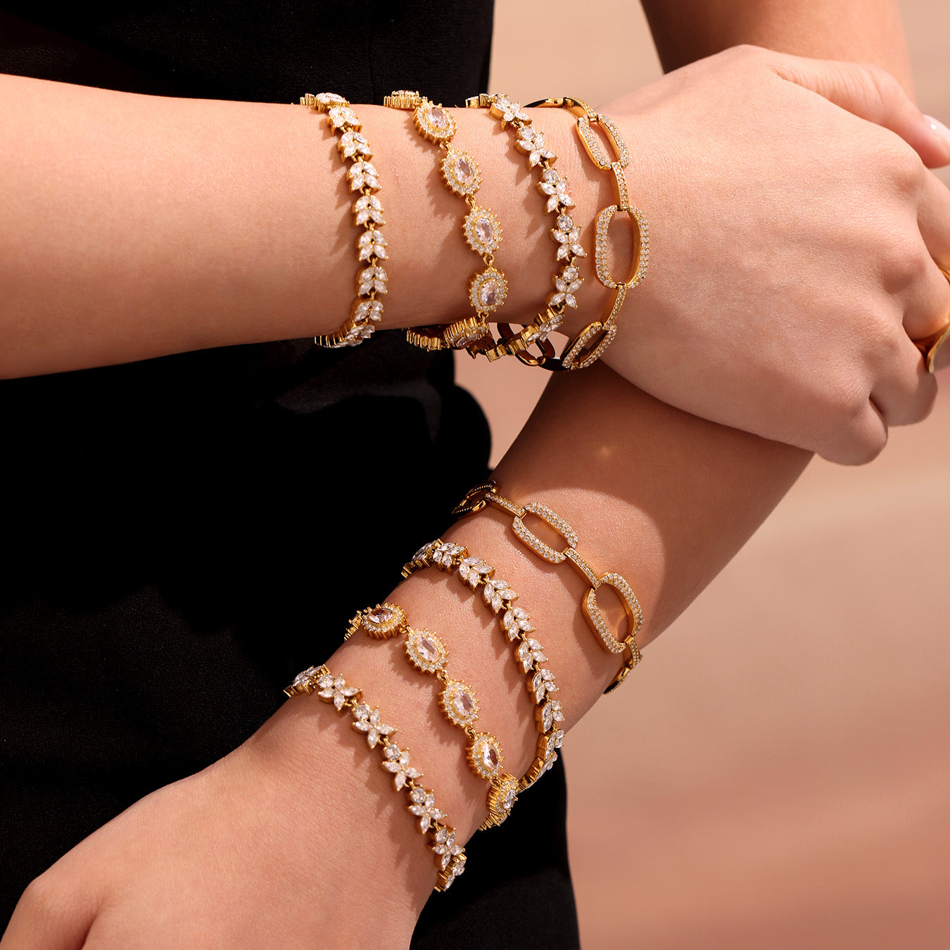 Model styling multiple gold zircon bracelets across both wrists