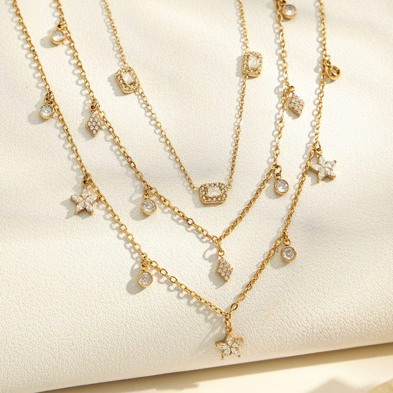 Gold zircon charm necklaces and bracelets arranged for boutique wholesale jewelry display