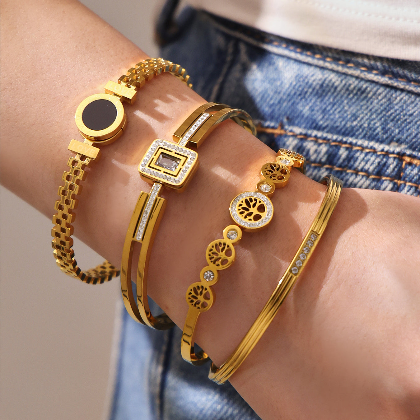 Multi-element 18K gold zircon clasp bangle set stacked on wrist, European luxury accessory