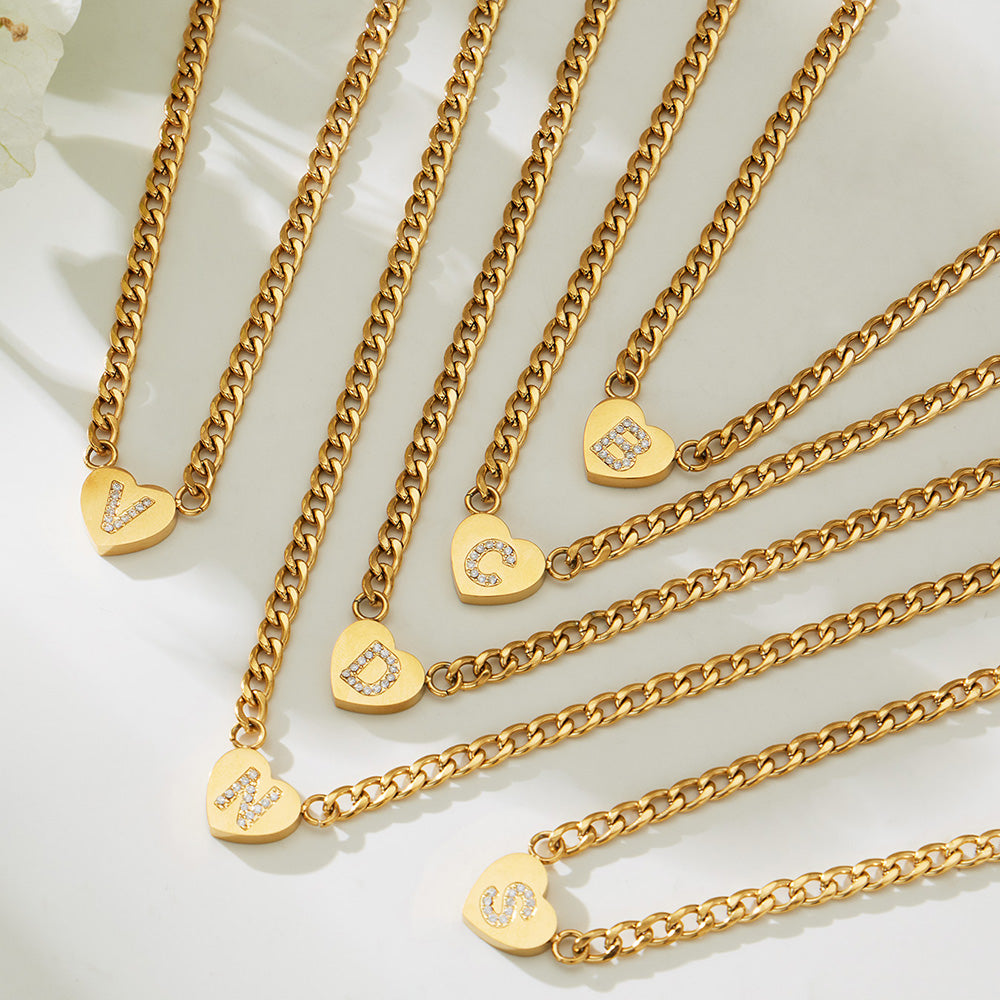 Gold-tone curb chain necklaces with assorted zircon initial heart charms displayed together