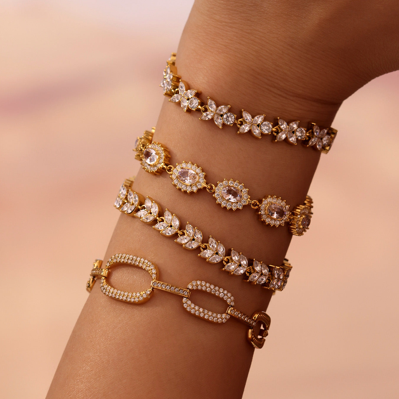 Layered gold zircon bracelets with pavé, floral and oval link designs