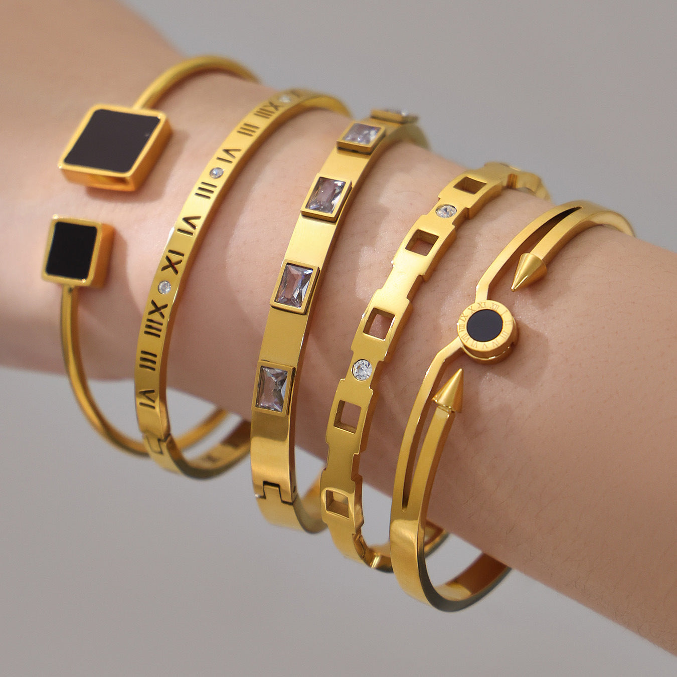 18k gold zircon stainless steel bangle set, layered on model's wrist