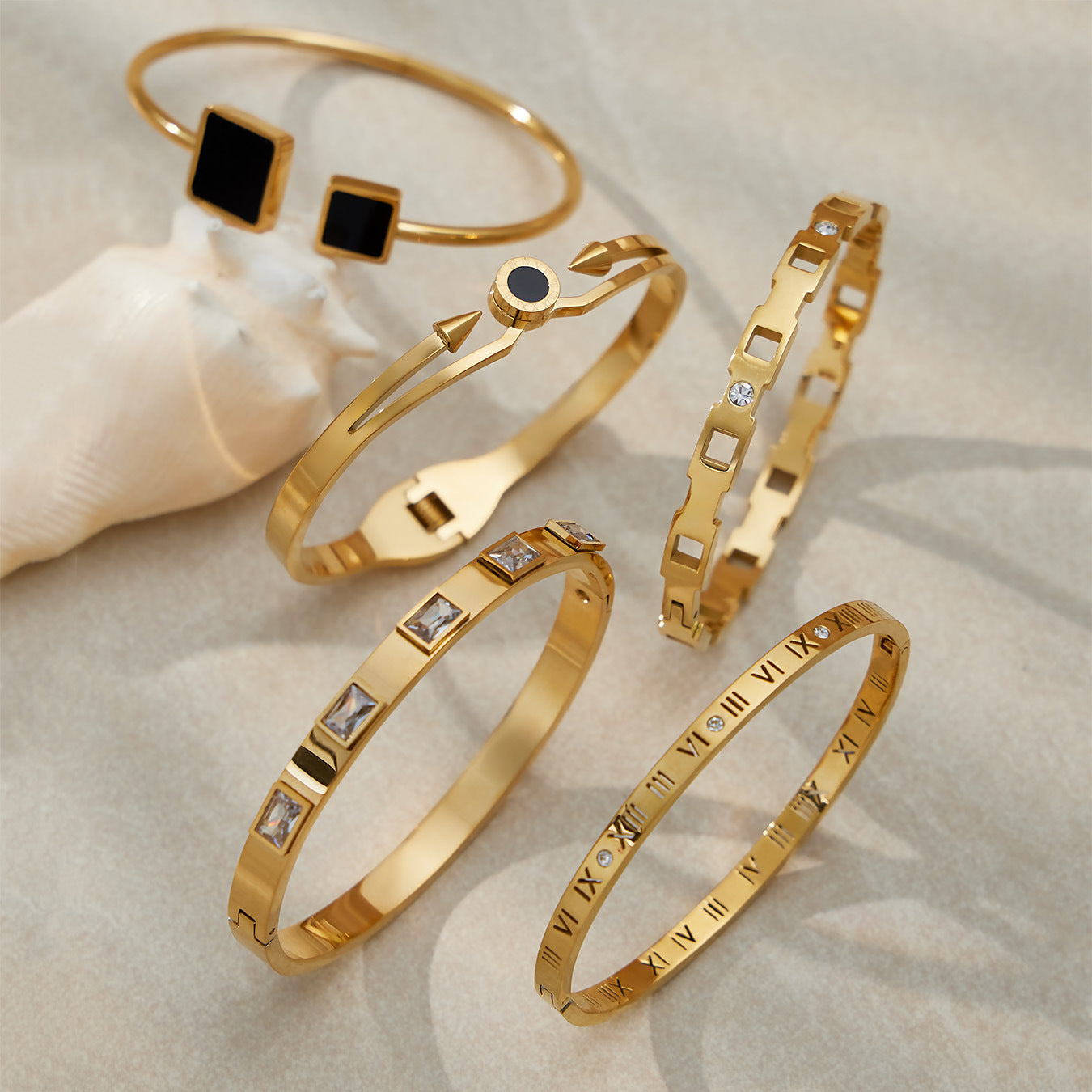 18k gold zircon stainless steel bangle set, displayed on textured surface