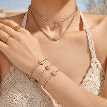 Model wearing gold zircon tennis necklace and bracelet set with waterdrop and oval pendant styles