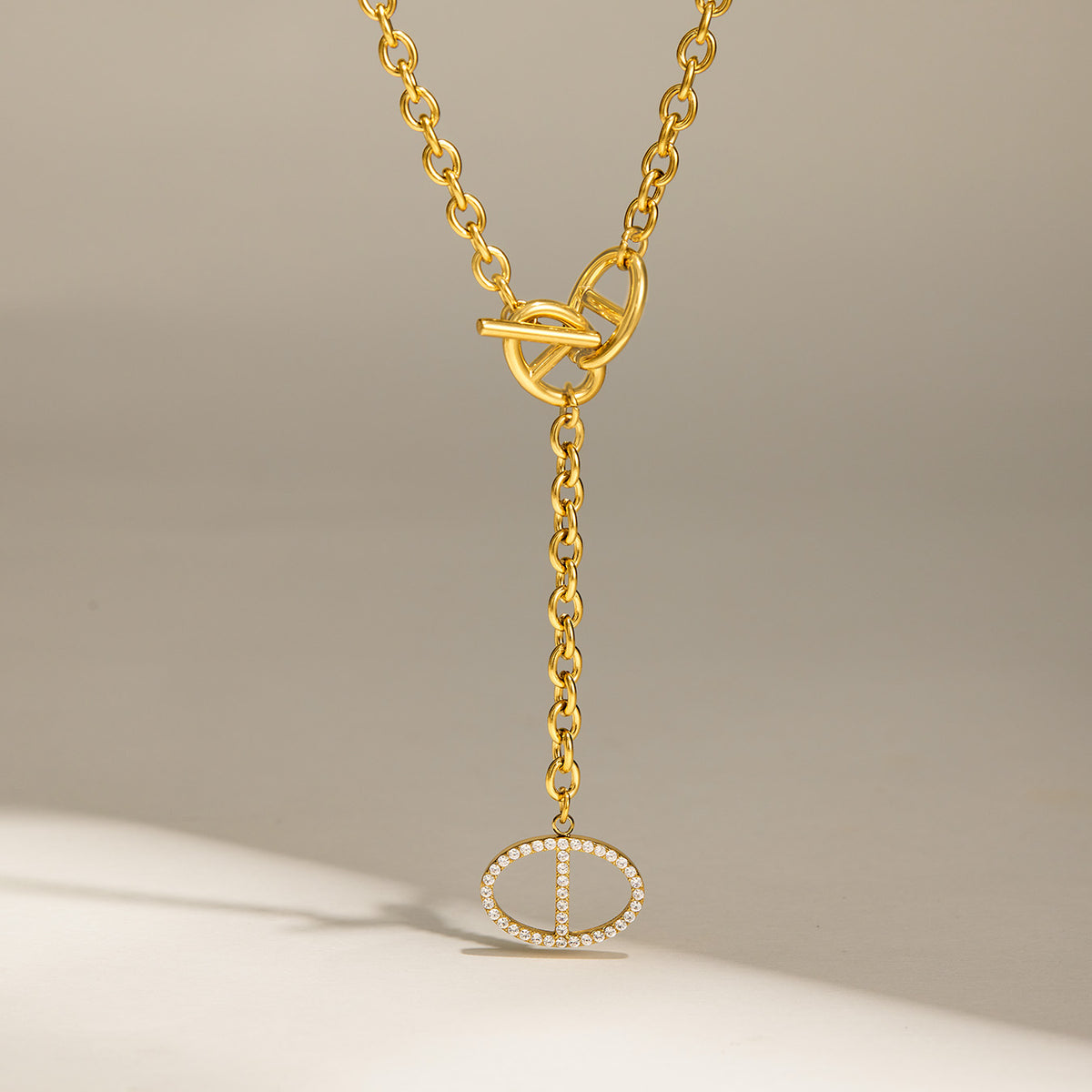 Gold zircon toggle drop necklace with front toggle closure and geometric pendant