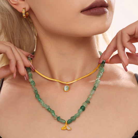 Model wearing a green beaded layered necklace with a delicate gold oval pendant chain