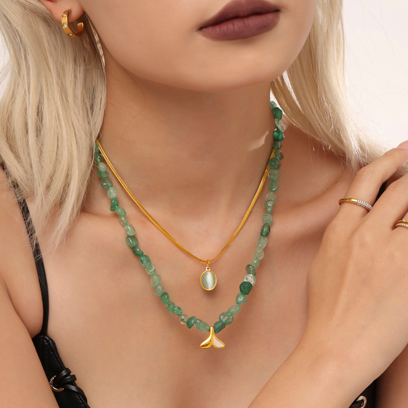 Green beaded and gold chain layered necklace styled with a black top