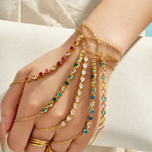 Model wearing a green cubic zirconia hand chain bracelet with gold stainless steel chain