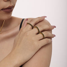 Green glass eternity ring worn on the finger with polished 18K PVD gold finish