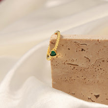 Side detail of an 18K gold-plated copper ring with green heart zircon accents
