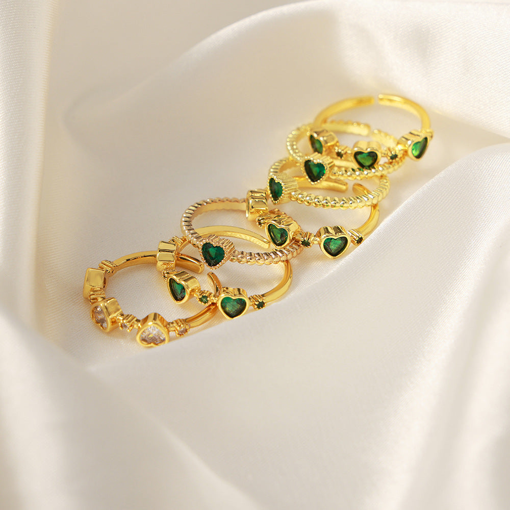 Green heart zircon rings arranged on ivory satin for a boutique jewelry display