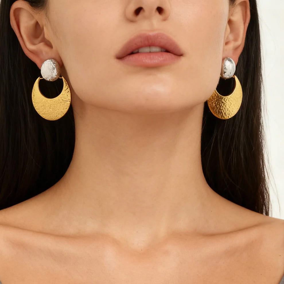 Front view of woman wearing bold statement 18K gold PVD plated hammered crescent jewelry.