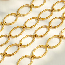 Close-up of textured hammered oval links on a gold chain necklace and bracelet