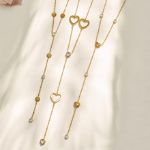 Gold heart, floral and butterfly Y necklaces displayed in a vertical assortment