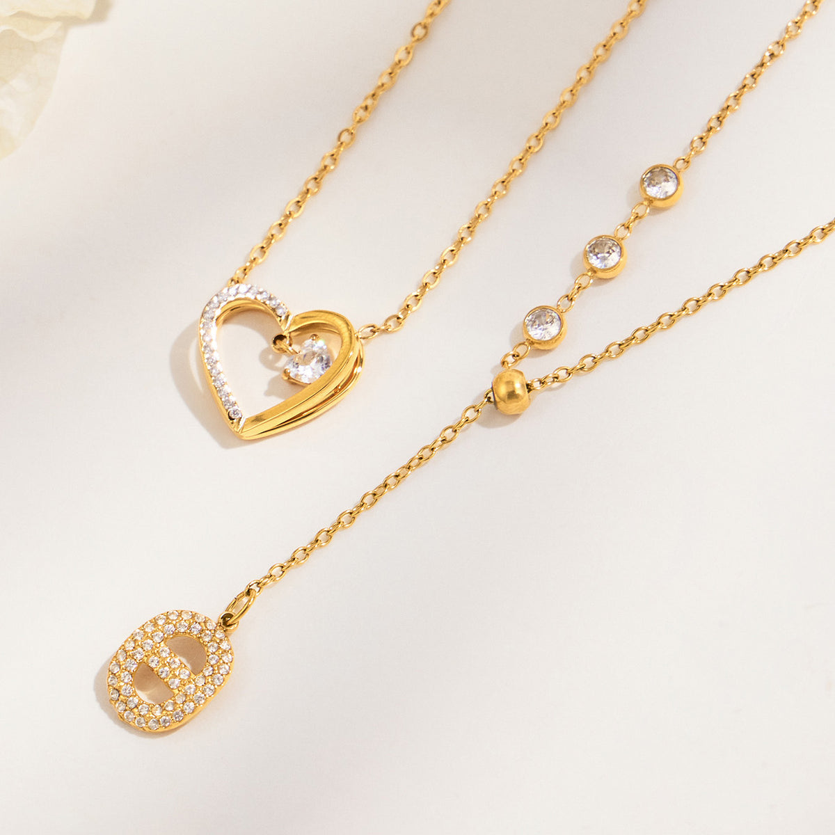 Gold-tone heart pendant necklace and zircon Y necklace displayed side by side