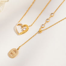 Gold-tone heart pendant necklace and zircon Y necklace displayed side by side