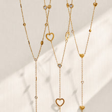 Gold heart and sunflower lariat necklaces displayed together on a light background