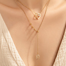 Gold-tone zircon heart and Y necklaces layered together on model