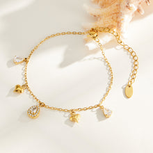 Gold-tone heart charm bracelet with clear teardrop zircon accents flat lay