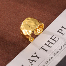 Close-up of irregular hammered gold ring texture and open band design