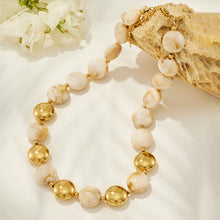 Ivory resin bead necklace with gold-tone accents displayed on a neutral product background.
