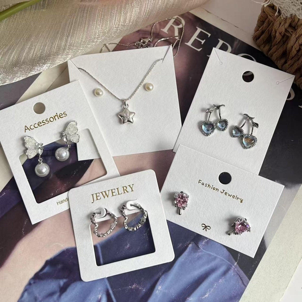 White jewelry display cards shown with earrings in a boutique packaging setup