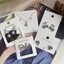 White jewelry display cards shown with earrings in a boutique packaging setup