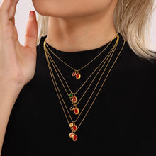 Model styling layered colorful zircon drop necklaces with red and green stones