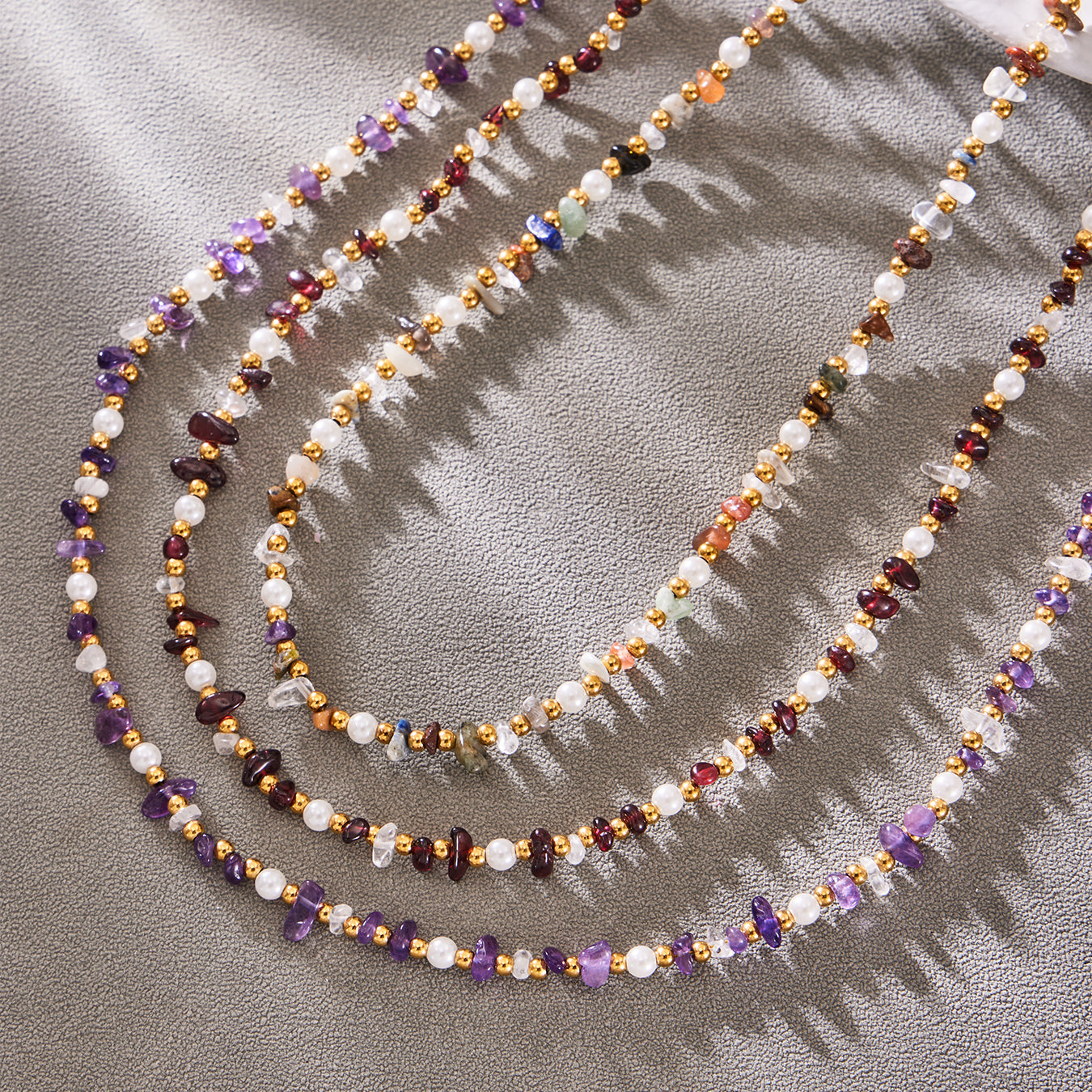 Close-up of layered gemstone beads and freshwater pearl accents on a necklace