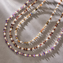 Close-up of layered gemstone beads and freshwater pearl accents on a necklace