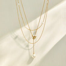 Layered gold necklace assortment with faux pearl, geometric and Y-shaped designs